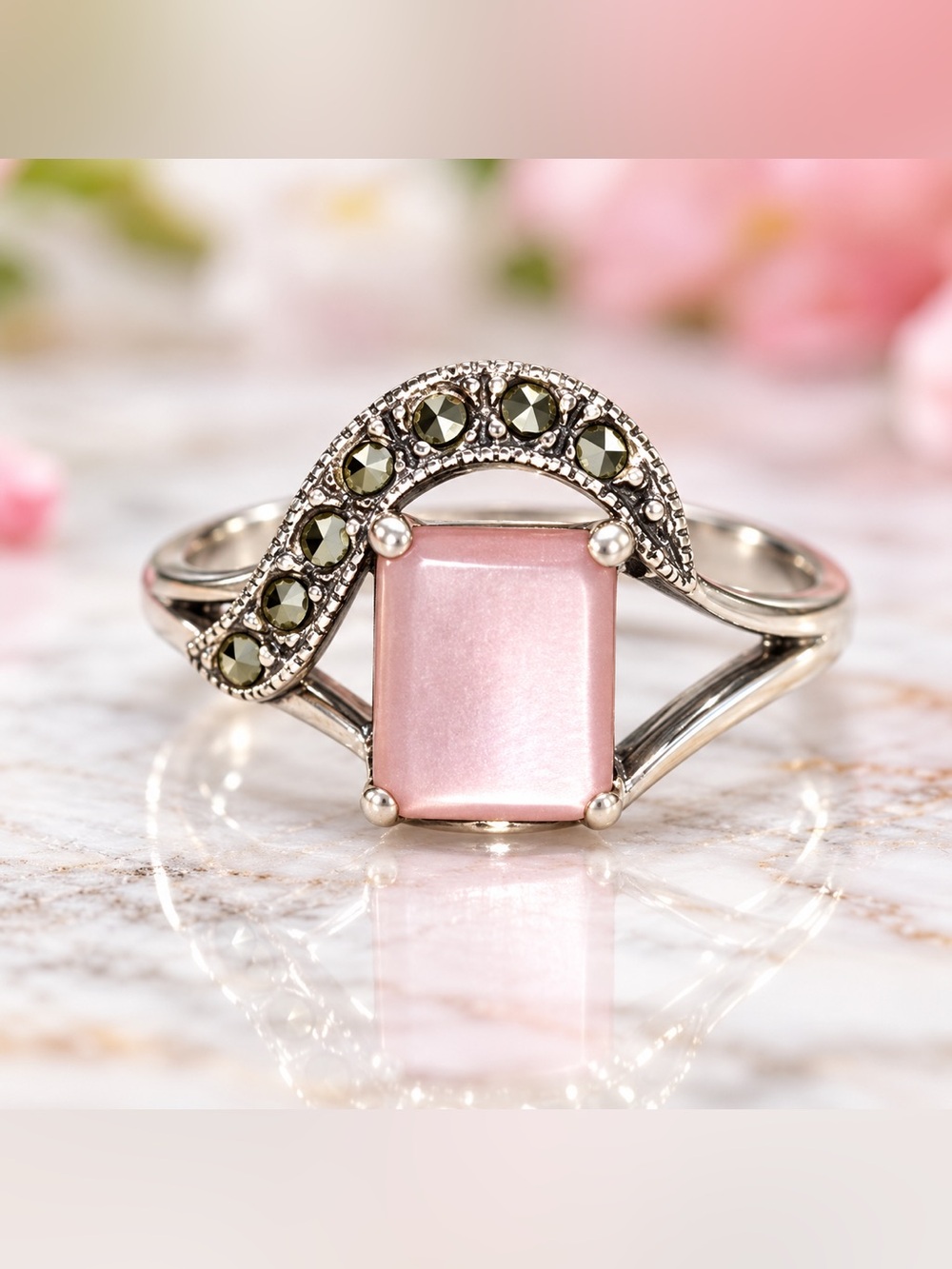 vintage-style sterling silver ring featuring a central rectangular pink gemstone